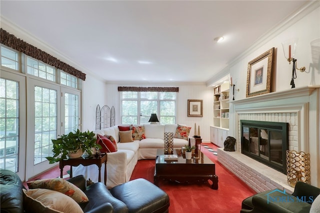 living room featuring a wealth of natural light, a fireplace, and crown molding