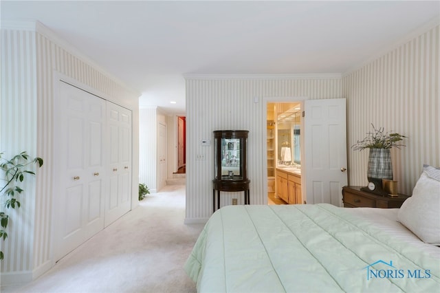 bedroom featuring light carpet, connected bathroom, a closet, and crown molding