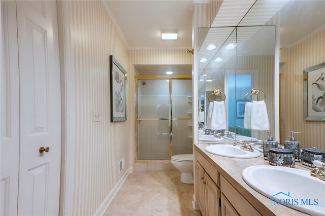 bathroom featuring crown molding, vanity, toilet, and a shower with shower door