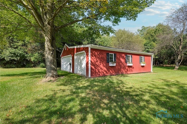 view of outbuilding with a garage and a lawn