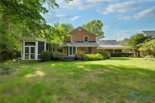 rear view of property with a lawn and a sunroom