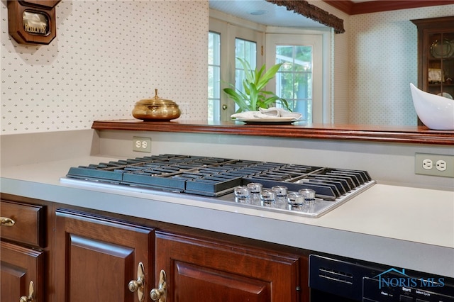 details with stainless steel gas stovetop, black dishwasher, and ornamental molding