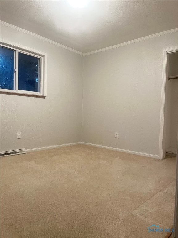 carpeted spare room featuring crown molding