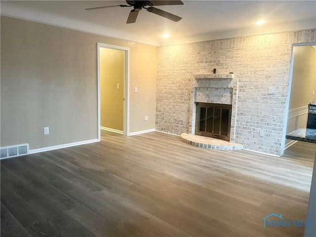 unfurnished living room with ceiling fan, hardwood / wood-style flooring, and a fireplace