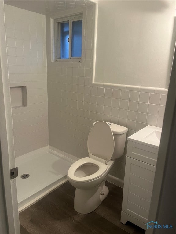 bathroom featuring tile walls, hardwood / wood-style flooring, vanity, and toilet