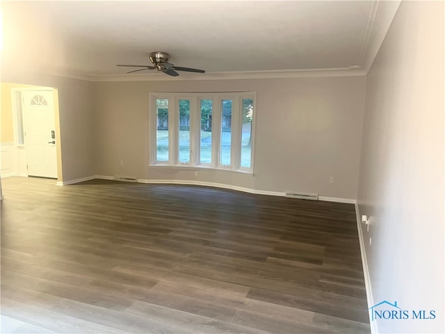 spare room featuring ceiling fan, ornamental molding, and dark wood-type flooring