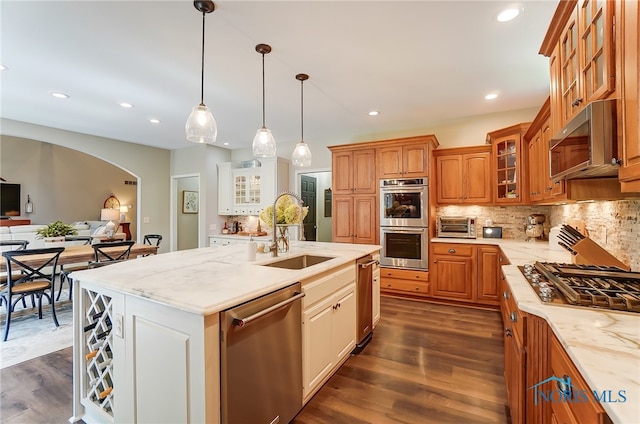 kitchen featuring dark hardwood / wood-style flooring, stainless steel appliances, a center island with sink, and sink