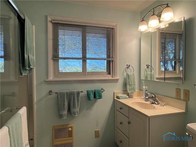 bathroom with vanity, toilet, and heating unit