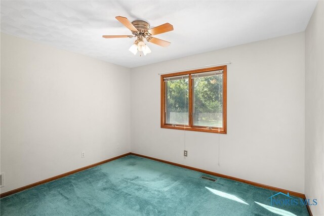 carpeted spare room with ceiling fan