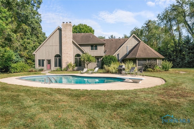 view of pool with a yard, area for grilling, a patio area, and a diving board