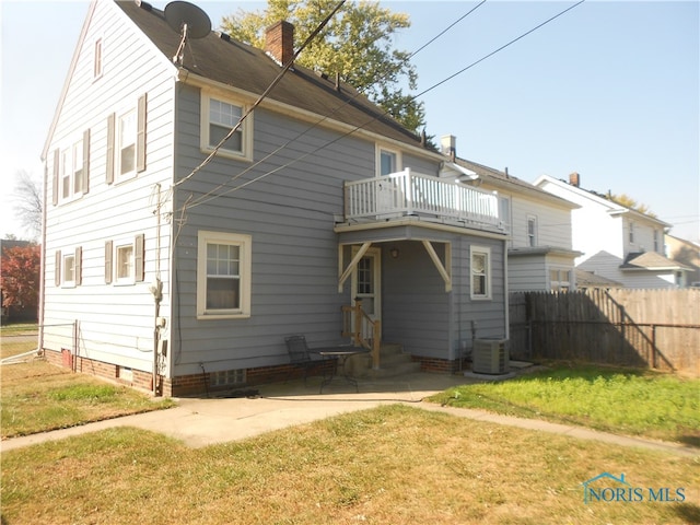 back of property featuring a balcony, a lawn, and central AC