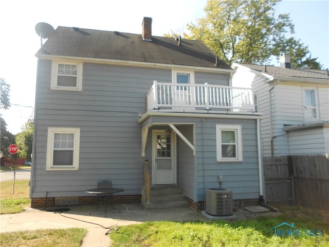 rear view of house with a balcony, central AC unit, and a patio area