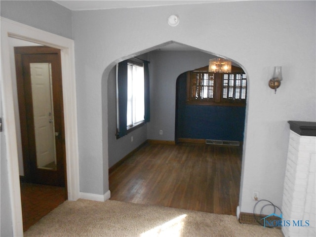 interior space with dark wood-type flooring and a chandelier