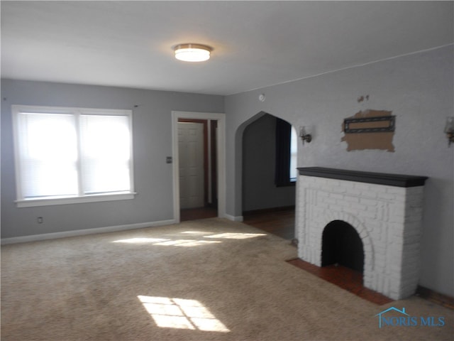 unfurnished living room featuring a fireplace and carpet flooring