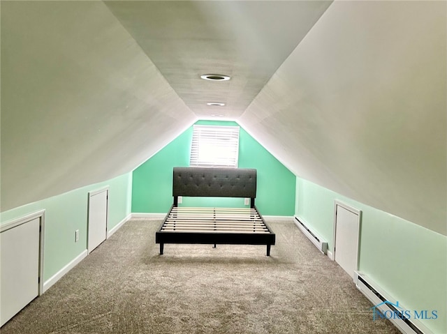 interior space with a baseboard radiator, vaulted ceiling, and carpet floors