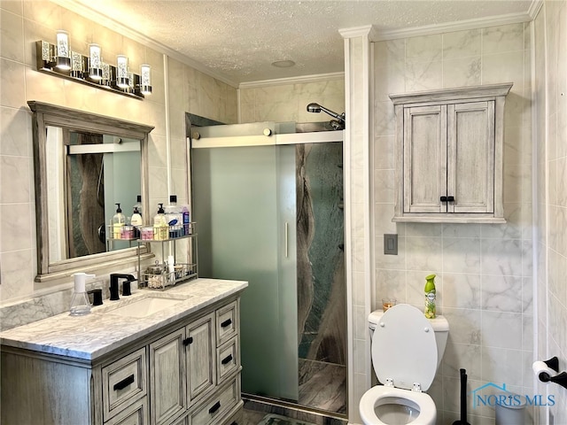 bathroom featuring tile walls, a shower with shower door, vanity, a textured ceiling, and toilet