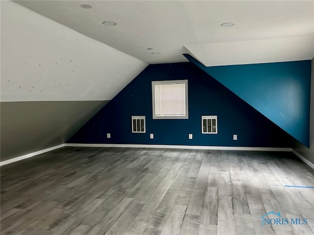 additional living space featuring vaulted ceiling and hardwood / wood-style floors