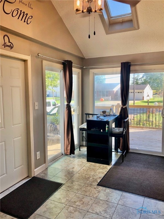 entrance foyer featuring a textured ceiling, plenty of natural light, and lofted ceiling with skylight