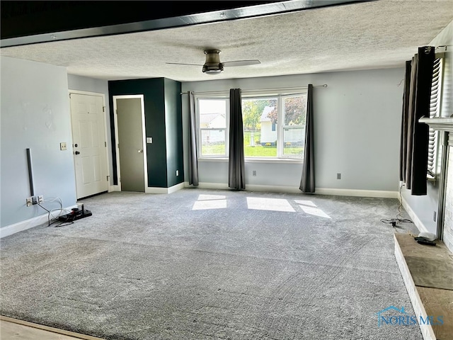 empty room featuring ceiling fan, light colored carpet, and a textured ceiling