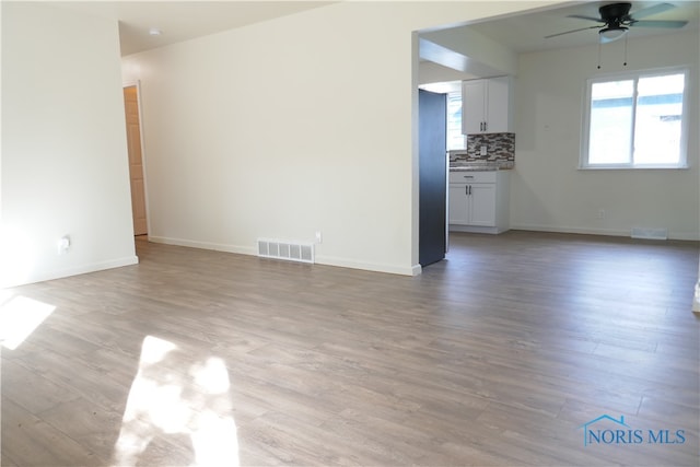 unfurnished living room featuring light hardwood / wood-style floors and ceiling fan