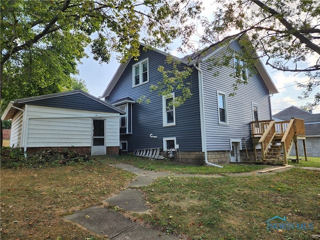 back of house featuring a wooden deck and a yard