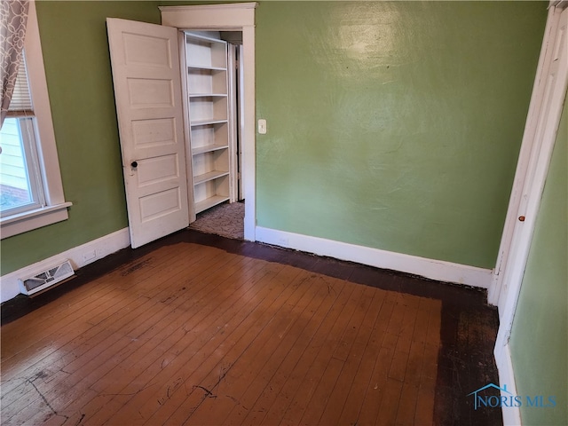 unfurnished room with dark wood-type flooring