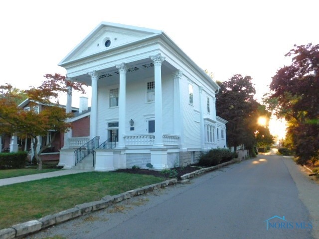 greek revival house featuring a front yard