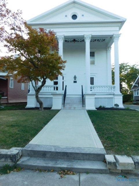 exterior space with a front yard and covered porch