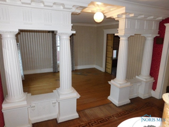 interior space featuring ornamental molding, hardwood / wood-style flooring, and decorative columns