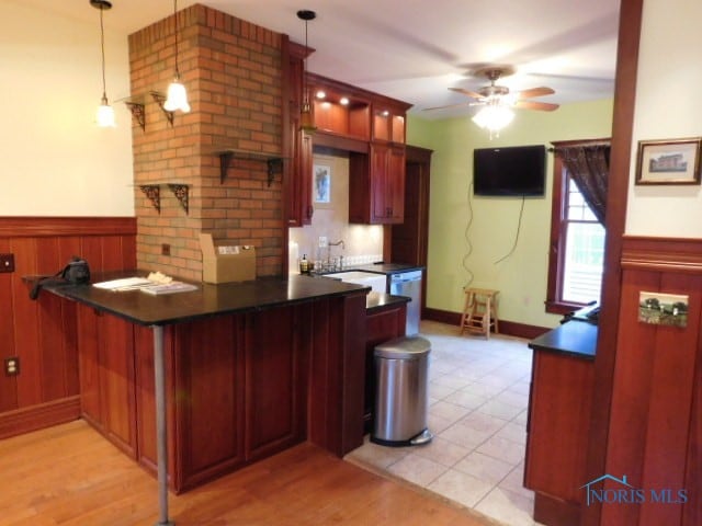 kitchen with light wood-type flooring, kitchen peninsula, ceiling fan, and decorative light fixtures