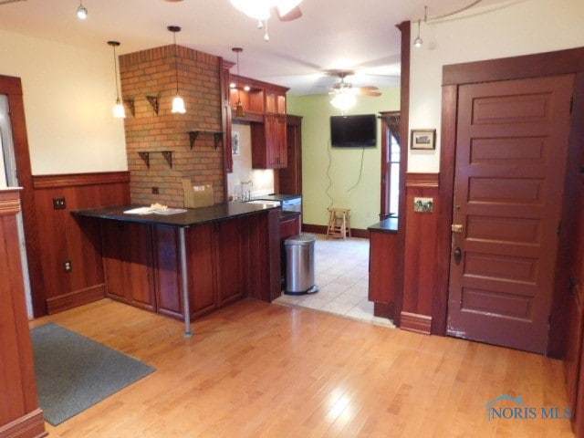 kitchen with light wood-type flooring, ceiling fan, hanging light fixtures, and kitchen peninsula