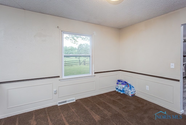 carpeted spare room featuring a textured ceiling