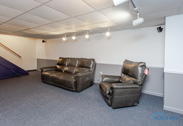 carpeted living room featuring a drop ceiling and rail lighting