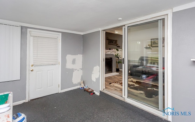 interior space featuring crown molding and dark colored carpet