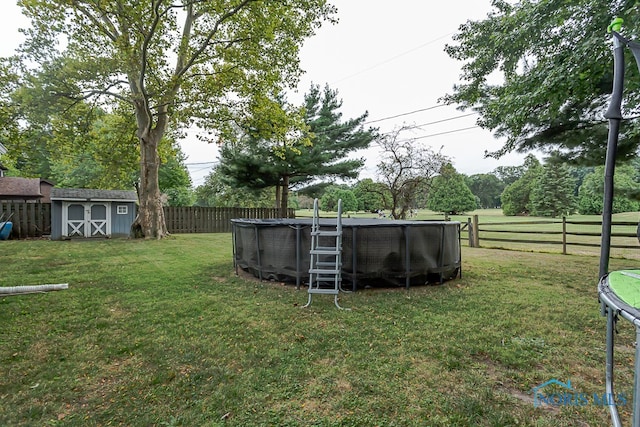 view of yard with a fenced in pool and a shed