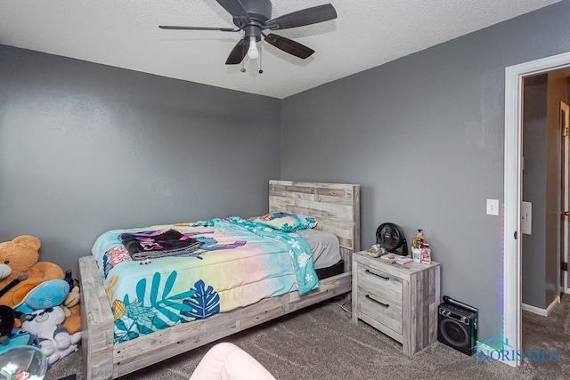 carpeted bedroom featuring ceiling fan and a textured ceiling