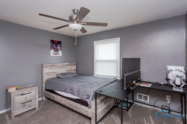 bedroom featuring ceiling fan, a textured ceiling, and dark carpet