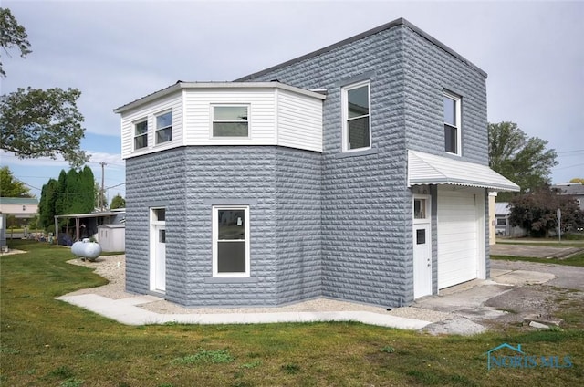 back of property with an attached garage and a yard