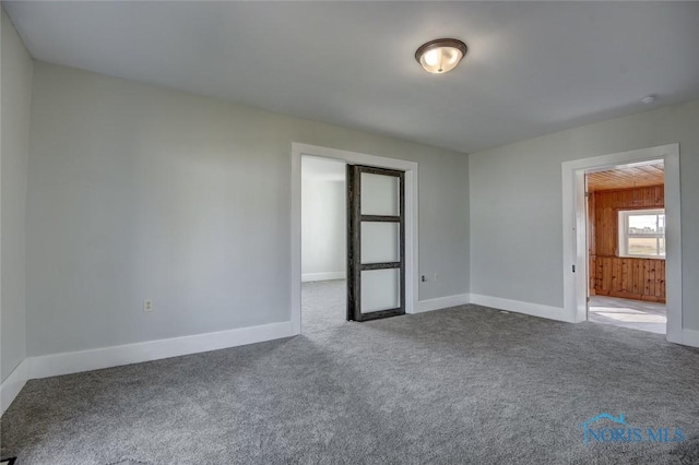 carpeted empty room with baseboards