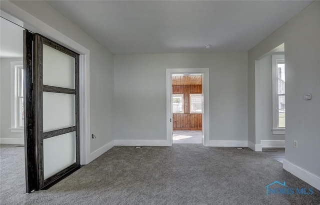 carpeted empty room with baseboards