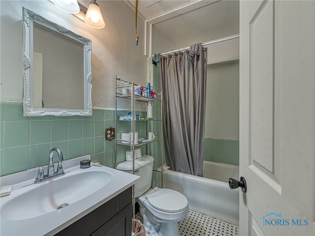 full bathroom with tile walls, shower / bath combo, vanity, and toilet