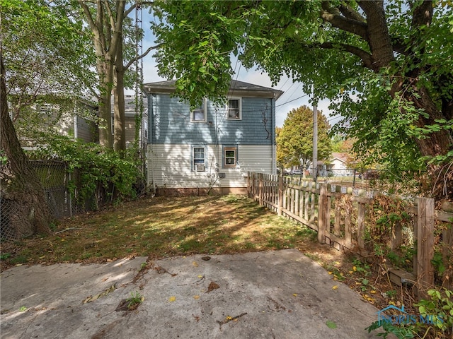 back of property with a yard and a patio area