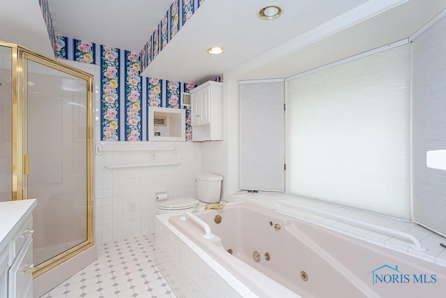 full bath featuring toilet, vanity, tile walls, a shower stall, and wallpapered walls