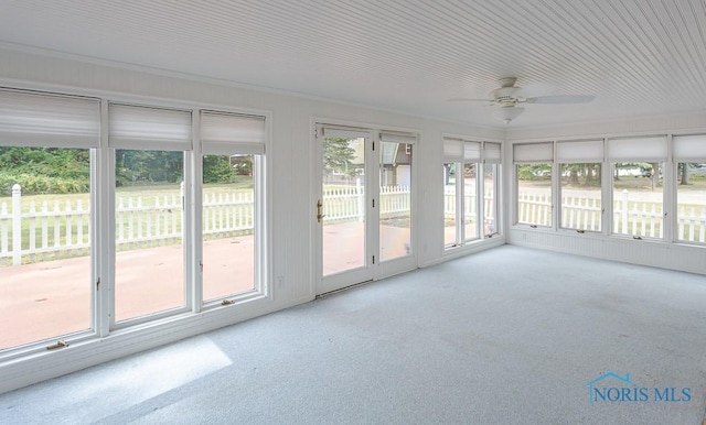 unfurnished sunroom with a ceiling fan and a wealth of natural light