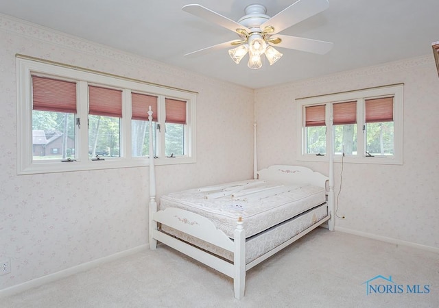 bedroom with light carpet, wallpapered walls, and multiple windows