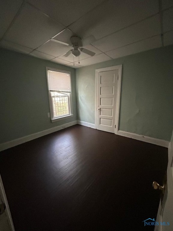 unfurnished room featuring a paneled ceiling, hardwood / wood-style flooring, and ceiling fan