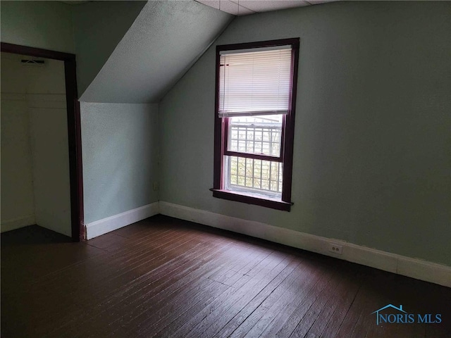 additional living space featuring dark hardwood / wood-style flooring and lofted ceiling