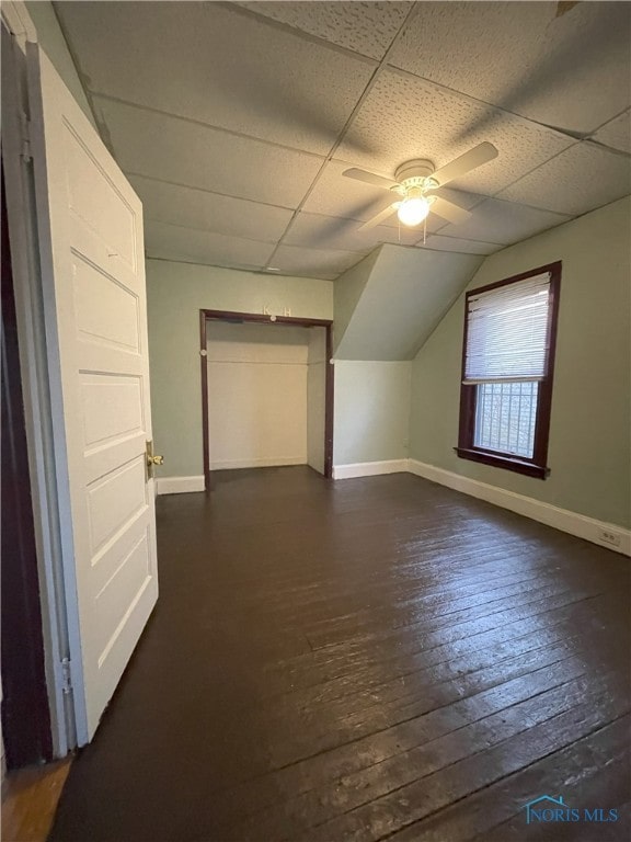 additional living space featuring dark wood-style floors, ceiling fan, baseboards, and vaulted ceiling