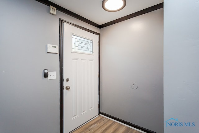 foyer featuring ornamental molding and light hardwood / wood-style floors