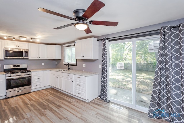 kitchen with a wealth of natural light, ceiling fan, appliances with stainless steel finishes, and sink